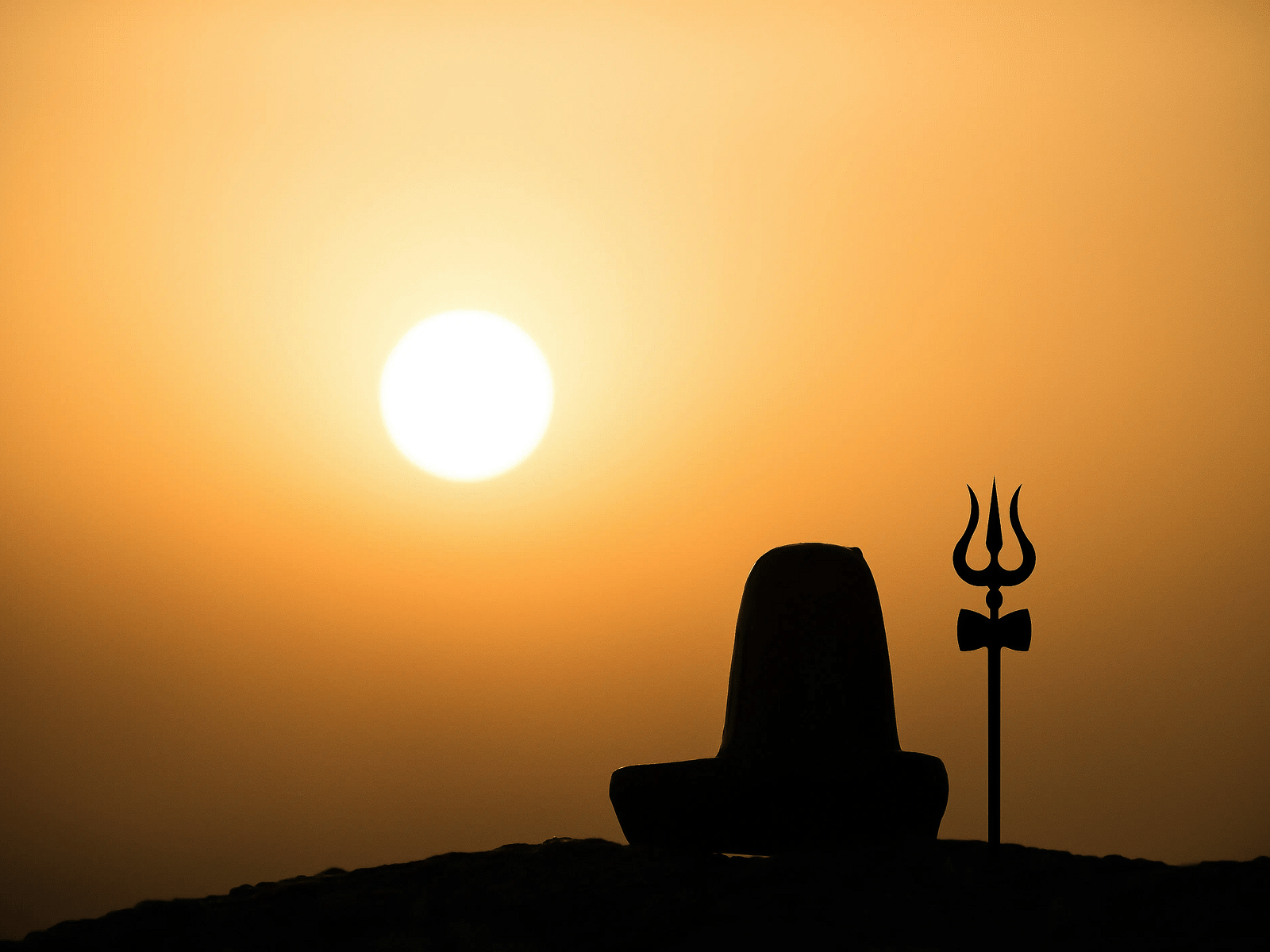 Shiv linga with a trishool against sunset e7ewpx