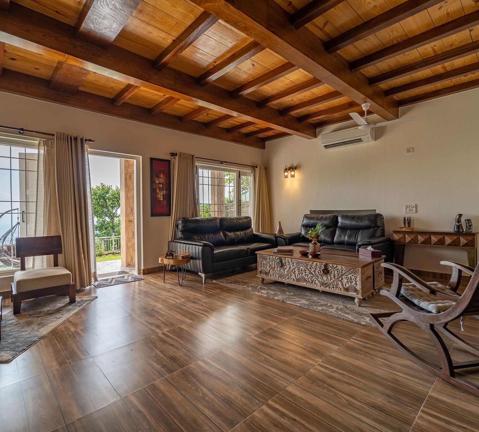 an overview of a living room with sofas and a coffee table inside one of the rooms - neer ganga Resorts