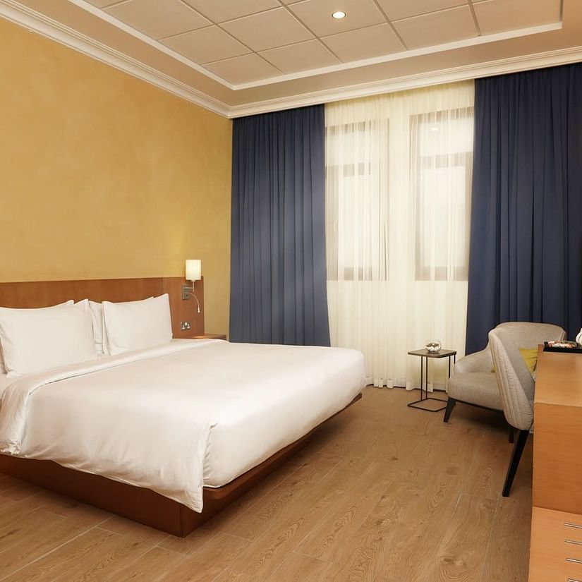 a king bed with side tables and lamps inside Classic King Room - La Maison Hotel, Doha