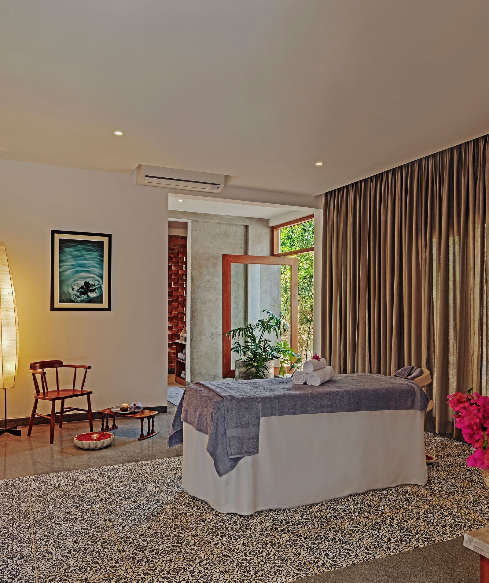 A  therapy room with a bed, curtains, and artwork, indoor setting - Shreyas Retreat