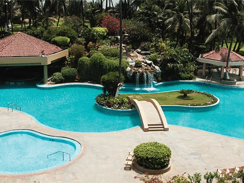 Aerial view of The Retreat Hotel and Convention Centre highlighting the outdoor swimming pool, poolside seating, palm trees and the resort-style layout of the property.