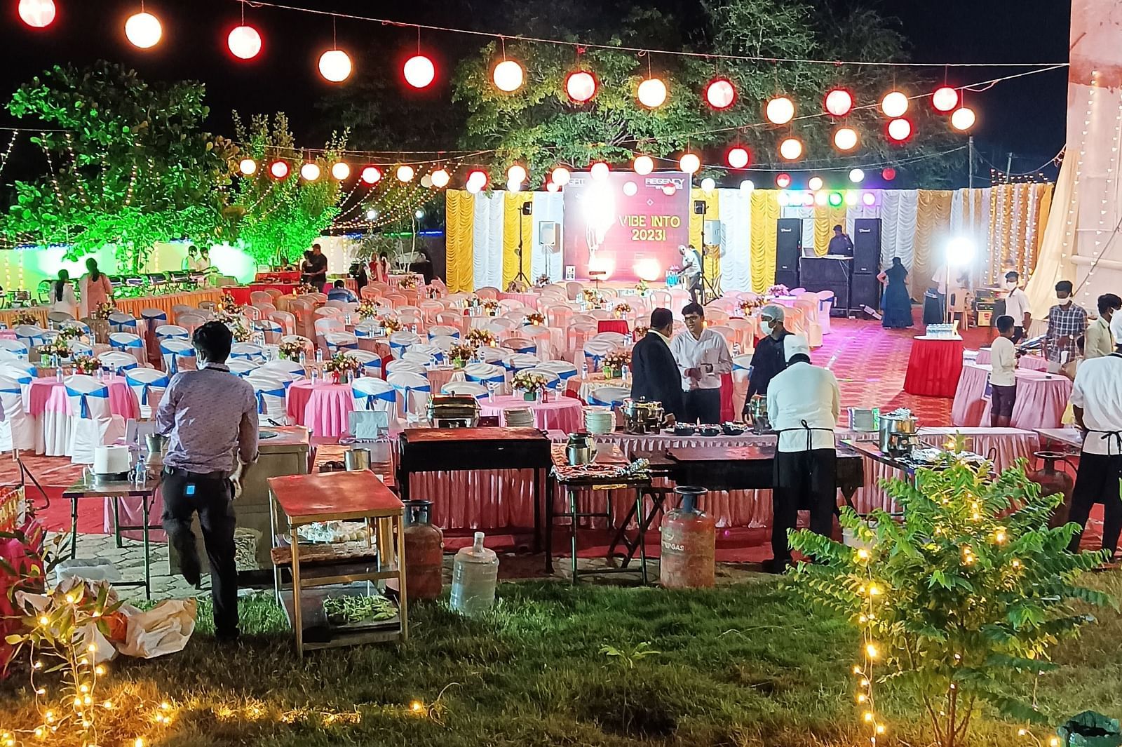 An event at our banquet hall in Tuticorin, with people engaged in conversations, set against a backdrop of a dark sky illuminated by lights around the venue - Regency Tuticorin by GRT Hotels