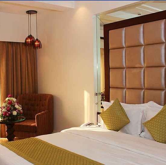 Image of a room with a bed and window on the side at Calux Grand Inn, Calangute.