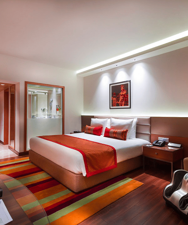 Grand Club Room with king size bed and sofa chair at Grand Chennai By GRT Hotels.