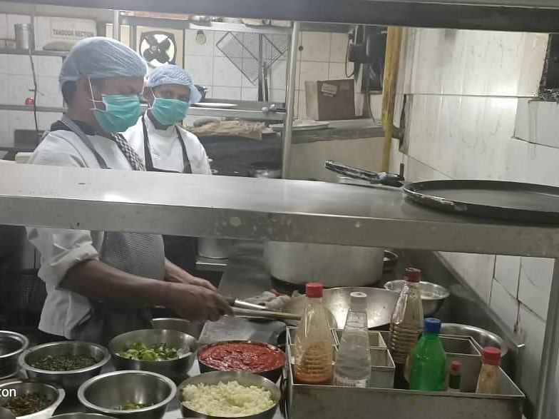 a close up shot of chefs inside a kitchen working on a dish - VITS Hotels & Resorts