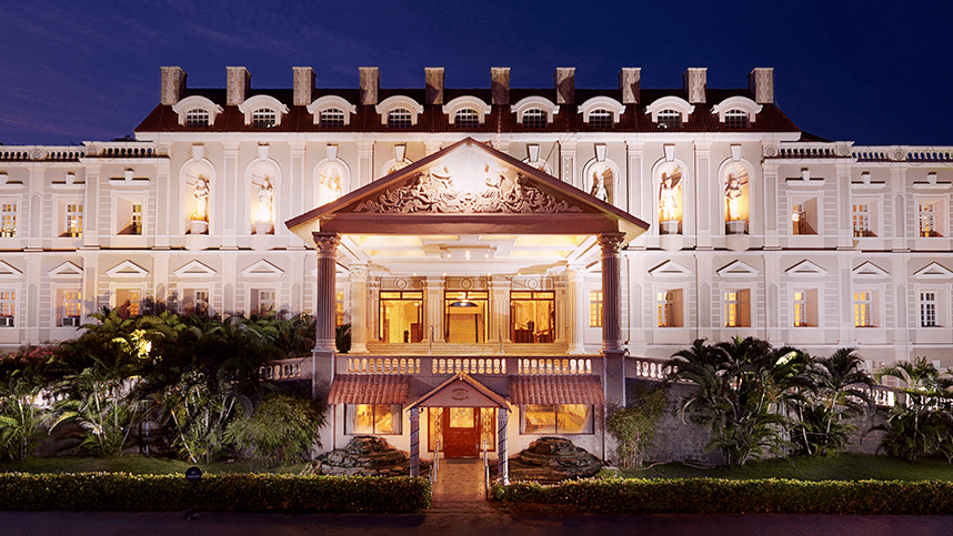 A wide exterior shot of the grand hotel building beautifully illuminated against the night sky - Jenneys Residency, Coimbatore