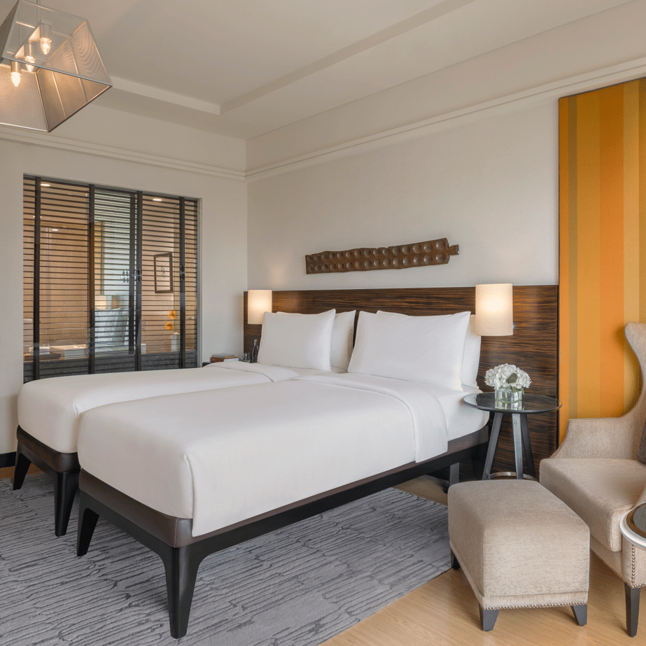 Guest room with double bed, armchair, and bedside lamps at The Raintree, St. Mary’s Road.