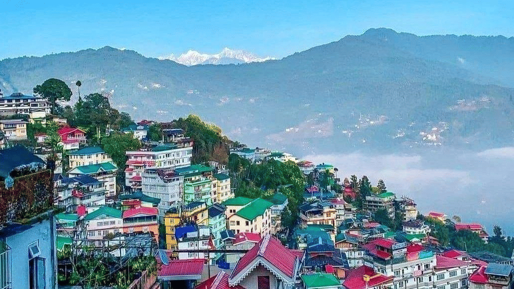 Colourful hillside buildings with mist and mountains in the background, representing the scenic setting of Voyage Hotels & Resorts.