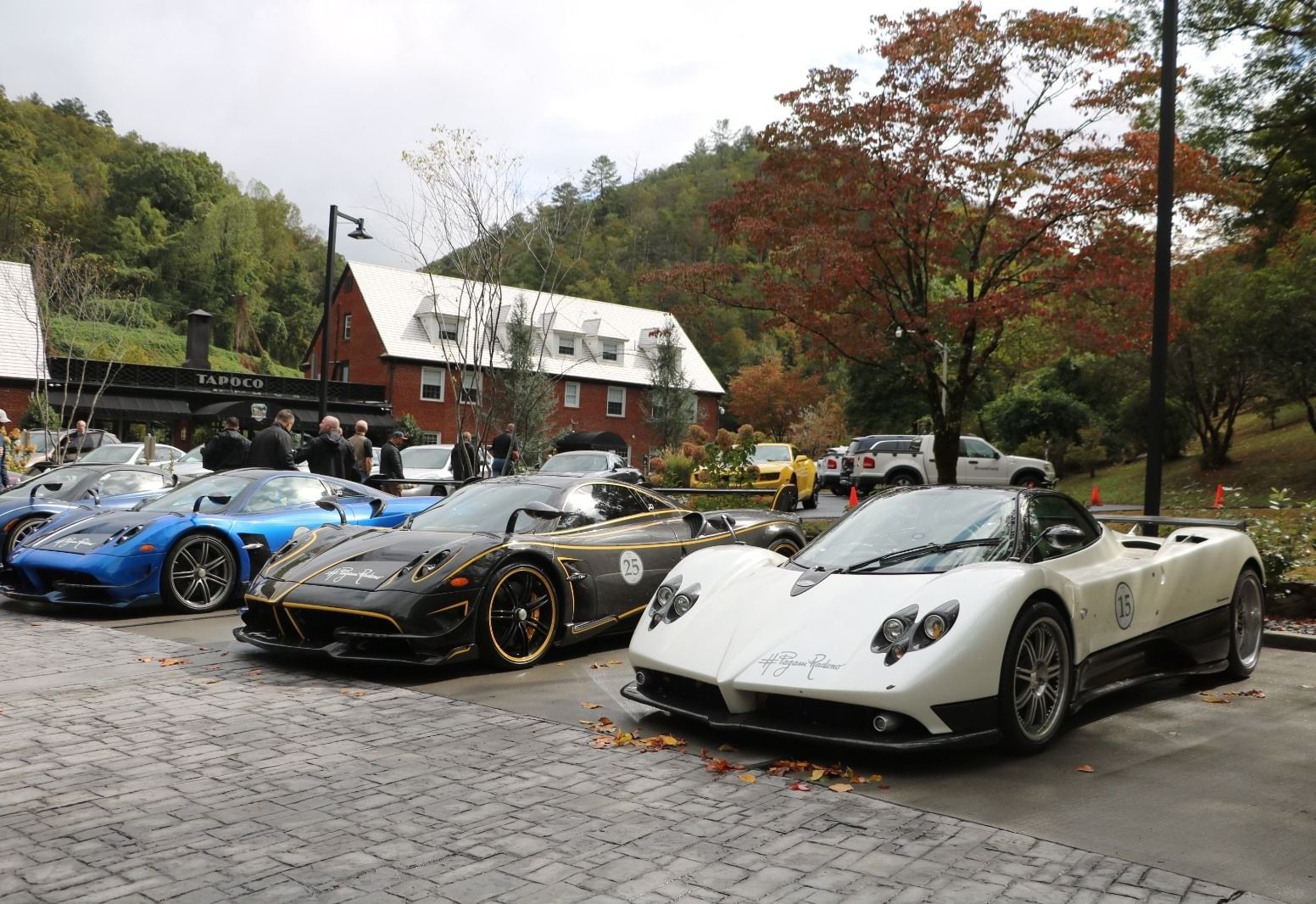 Corner view shot of several sport cars parked together at the Historic Tapoco Lodge surrounded by trees.