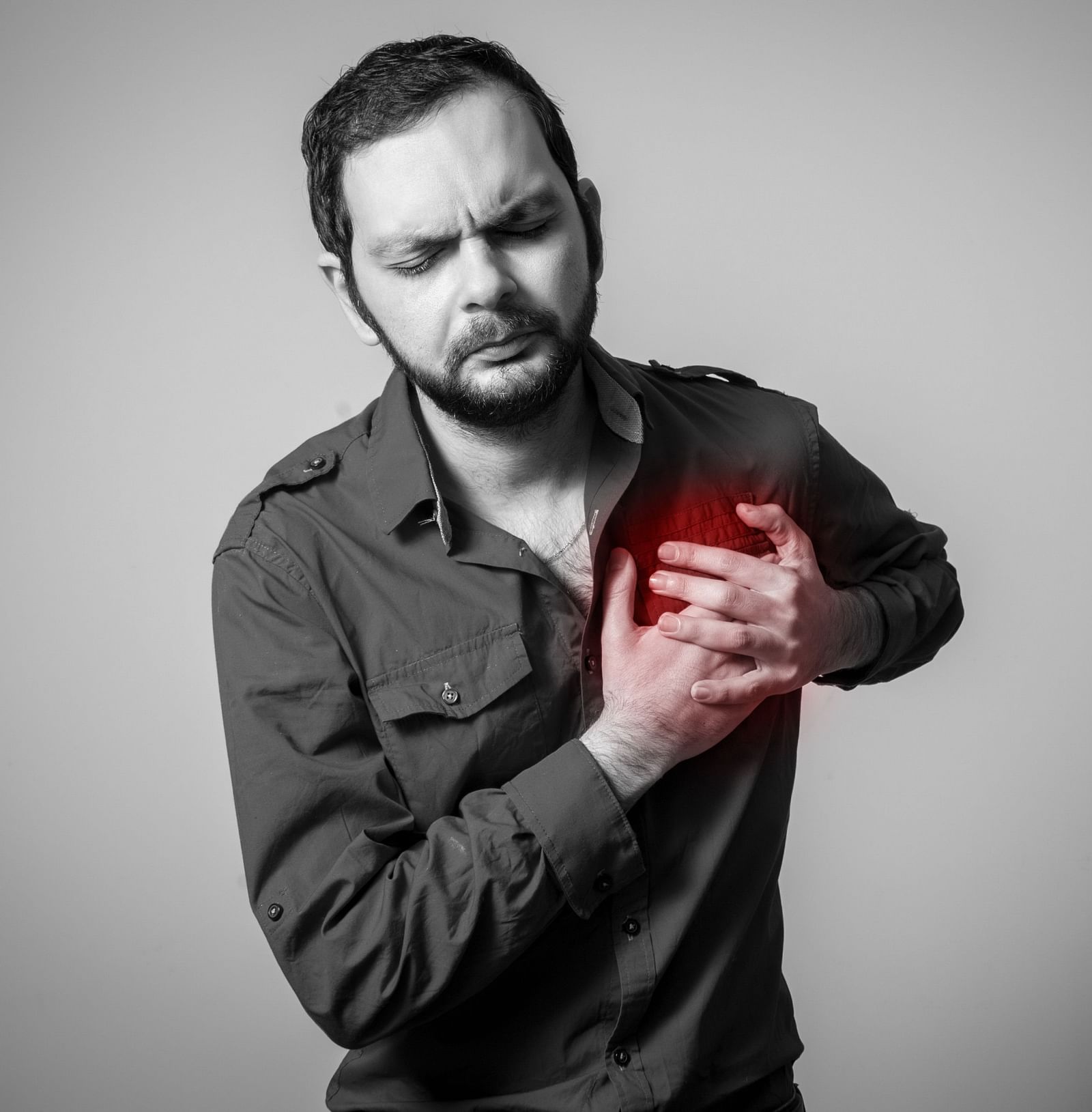A man clutching his chest, experiencing chest pain - Shreyas Retreat