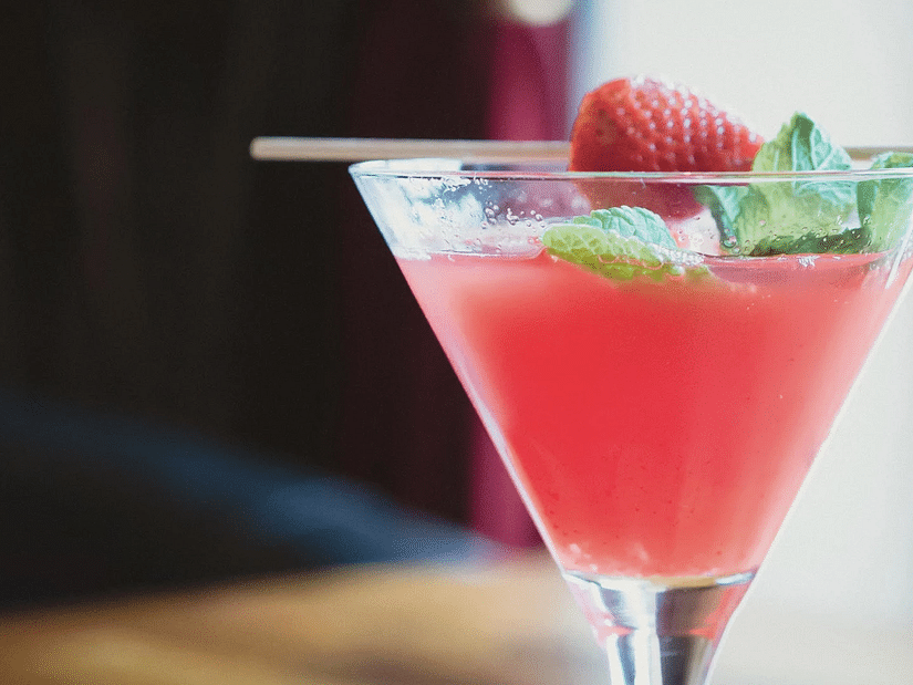 A refreshing cocktail garnished with a berry and mint leaves - S Hotel Kingston, Jamaica