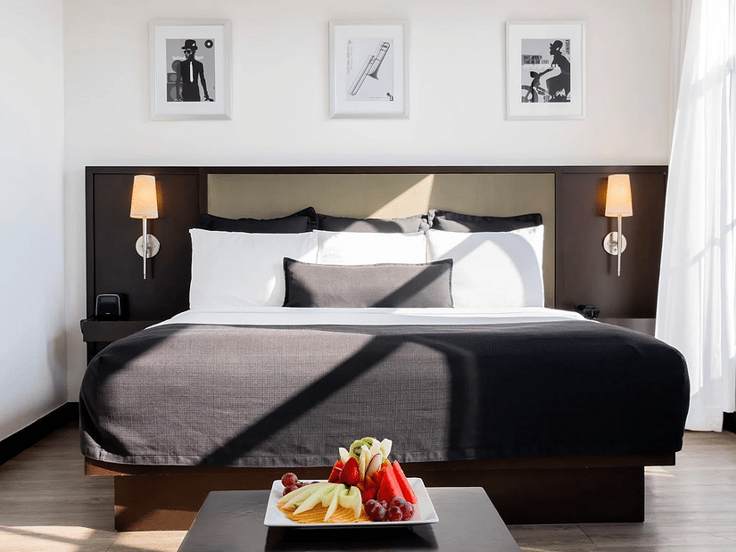 An image of a hotel room in Kingston with sunlight peaking thorough the large window on the bed - S Hotel Kingston, Jamaica