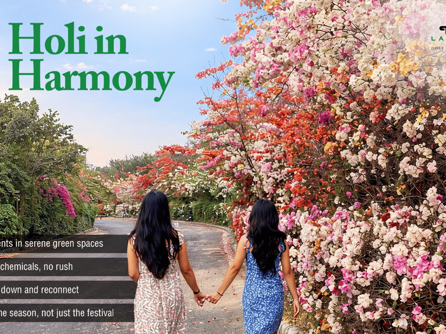 Two people walk hand-in-hand along a flower-lined path at Karma Lakelands, promoting Holi in Harmony, a serene, chemical-free celebration.