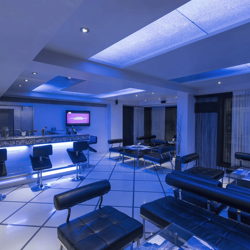 The bar interior with blue ambient lighting, a stylish counter, and sleek seating - The Citrine