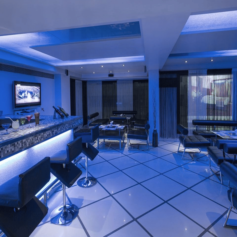 A modern blue-lit bar area with sleek seating and a contemporary, vibrant atmosphere - The Citrine