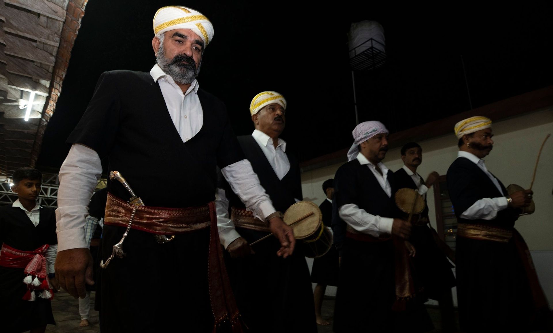 Men in traditional Kodava attire with drums.