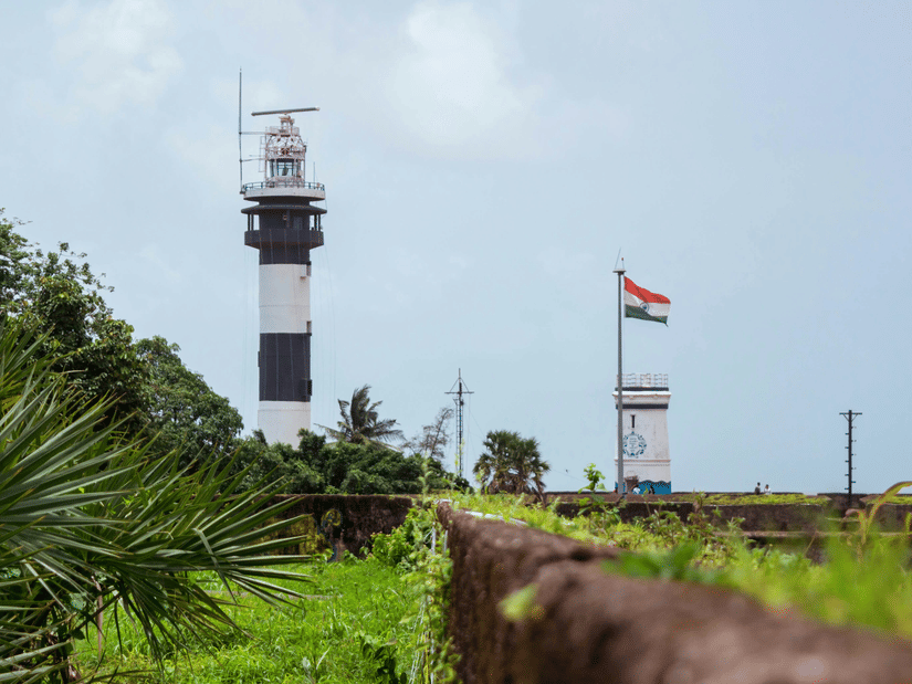 Daman Lighthouse during daytime with an Indian flag in view