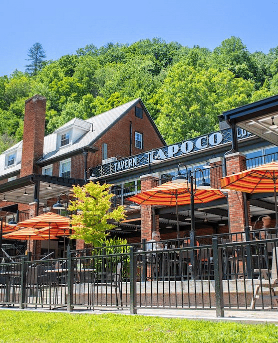 a bright facade image of the Historic Tapoco Lodge taken from a lower angle with a bright clear blue sky in the background - Historic Tapoco Lodge