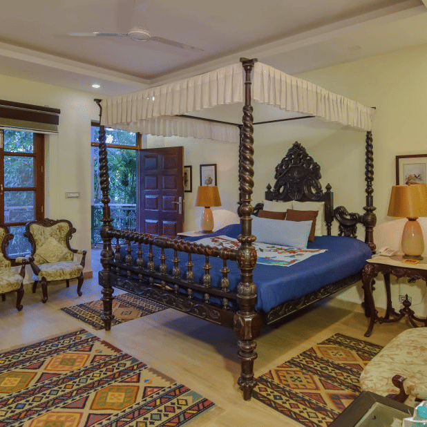 A spacious bedroom with a four-poster bed and a view of the outdoors.