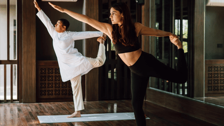 Two people practicing yoga in the morning light on yoga mats at Kavya Resort and Spa, Nagarkot