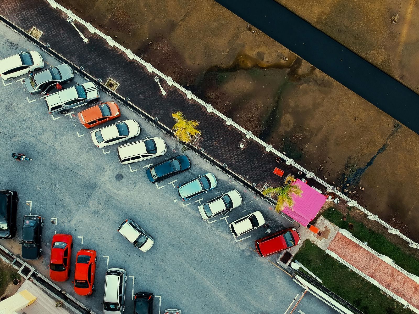 An aerial view of cars neatly parked side by side in a parking lot.