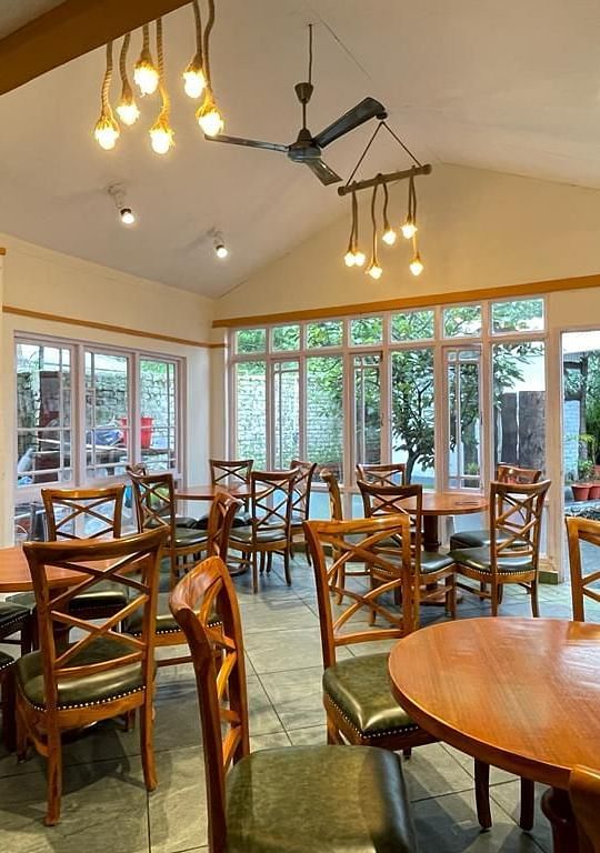  Wooden chairs and tables are neatly arranged in the dining area