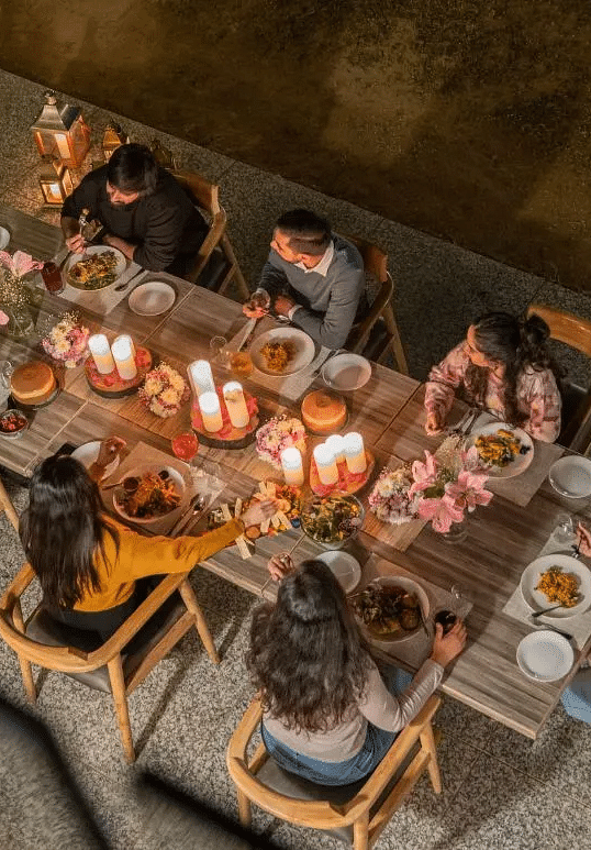 Overhead view of a group of people dining at a candle-lit table at Karma Chalets.