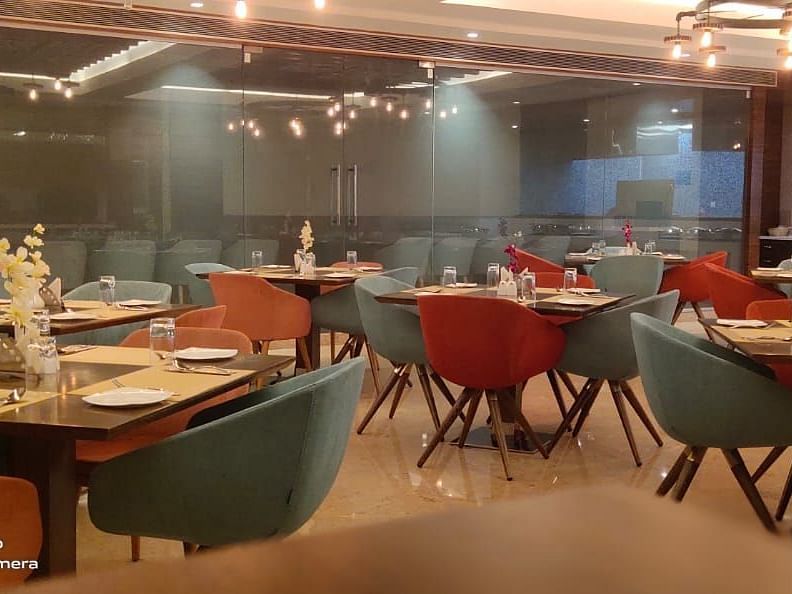 Upscale restaurant dining area with modern chairs and tables, part of Rang Lords Inn's amenities - Rang Lords Inn Bharuch