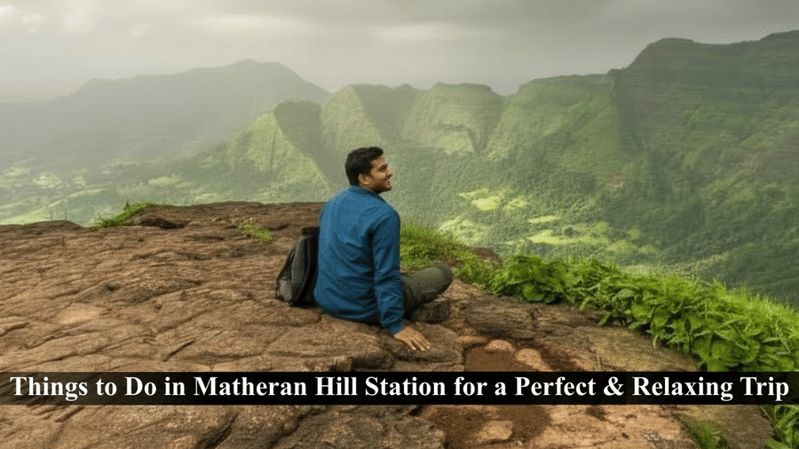 A panoramic view of a person sitting on a rocky cliff overlooking the lush green, misty valley of Matheran Hill Station.
