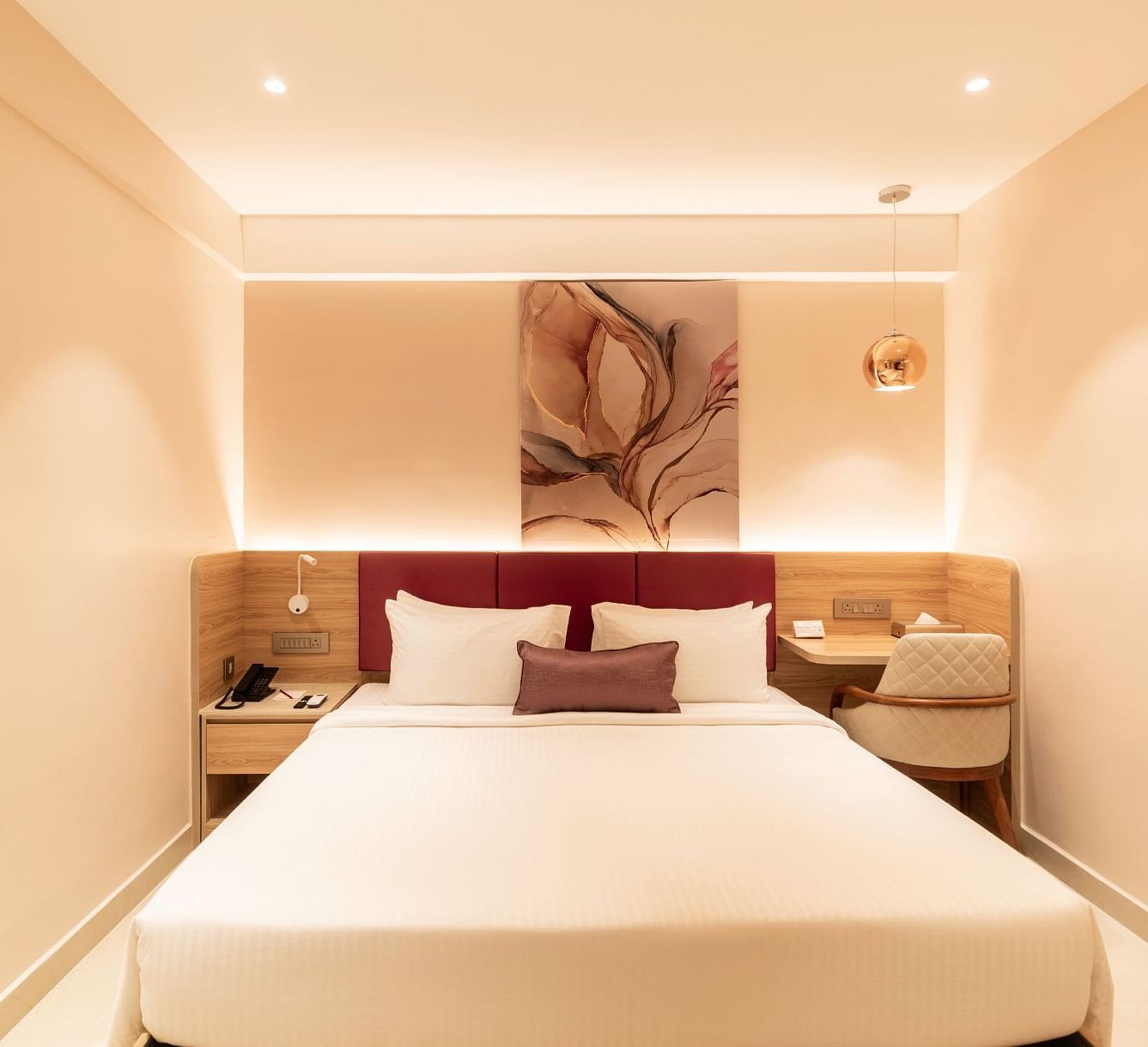King-sized bed with wall art in The Executive Rooms at TGI Livancia The Sojourn, Bangalore.