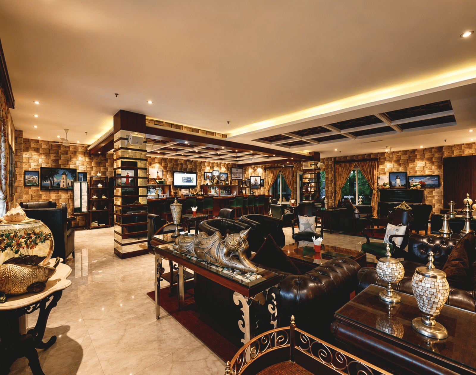 Lighthouse Bar with a wooden counter, green stools, leather sofas, brass lamps and lighthouse-themed wall art at MAYFAIR Palm Beach Resort, Gopalpur-on-Sea.