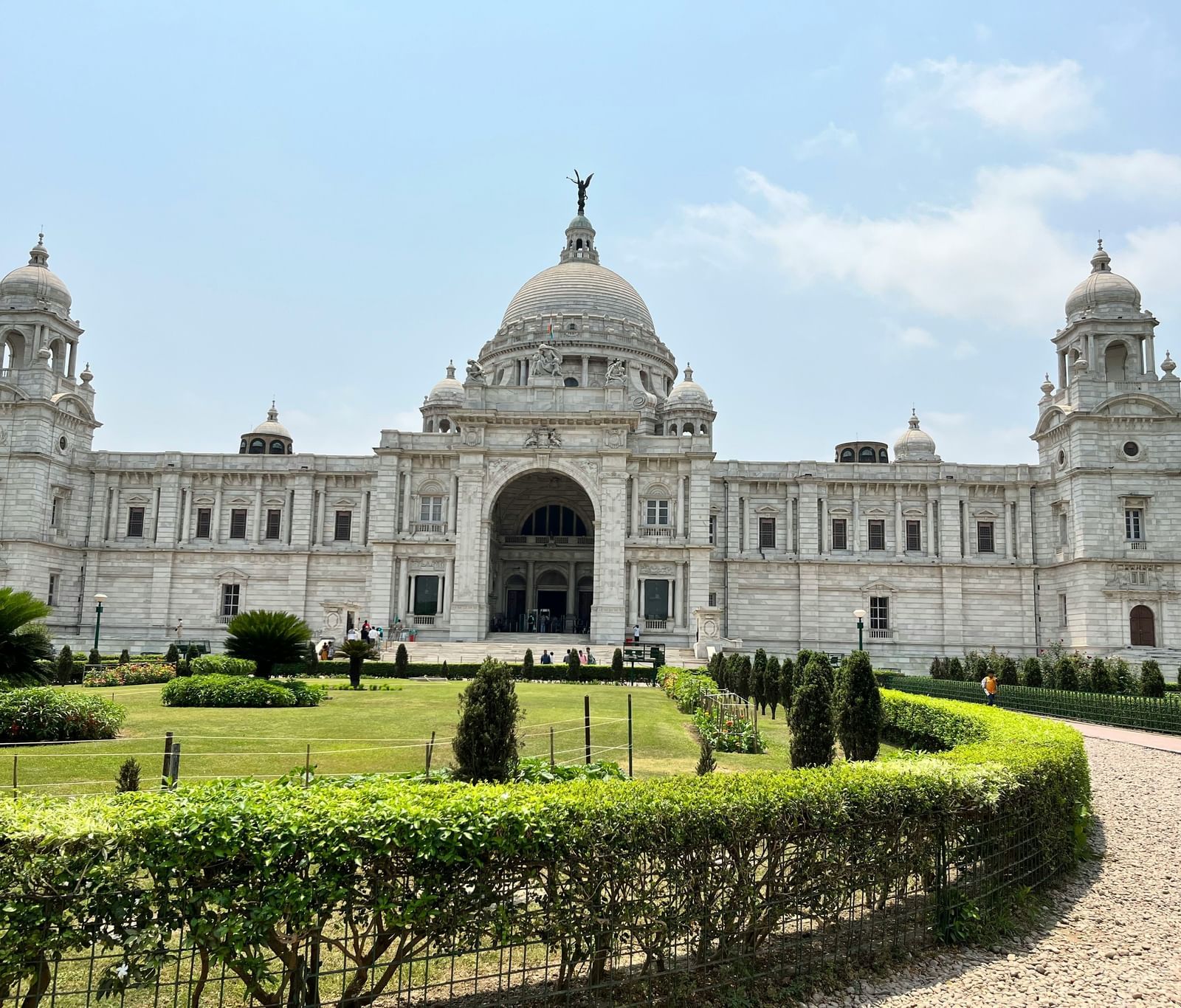 The pathway to the Victoria Memorial in Kolkata, surrounded by well-manicured gardens on either sides.