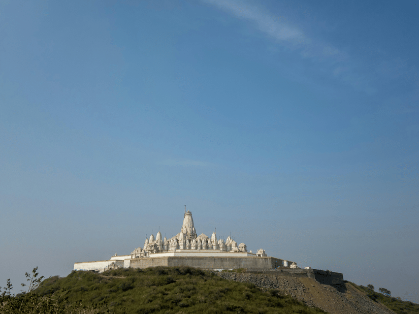 Parasnath Jain Temple on a hilltop as seen from afar with blue sky in the background - Parasnath Jharkhand