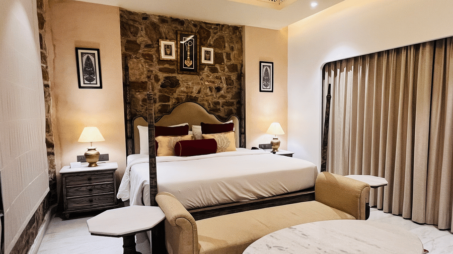 Premium Deluxe Room living area at Juna Mahal, Ranthambore with elegant seating, marble flooring, décor accents and spacious ambiance