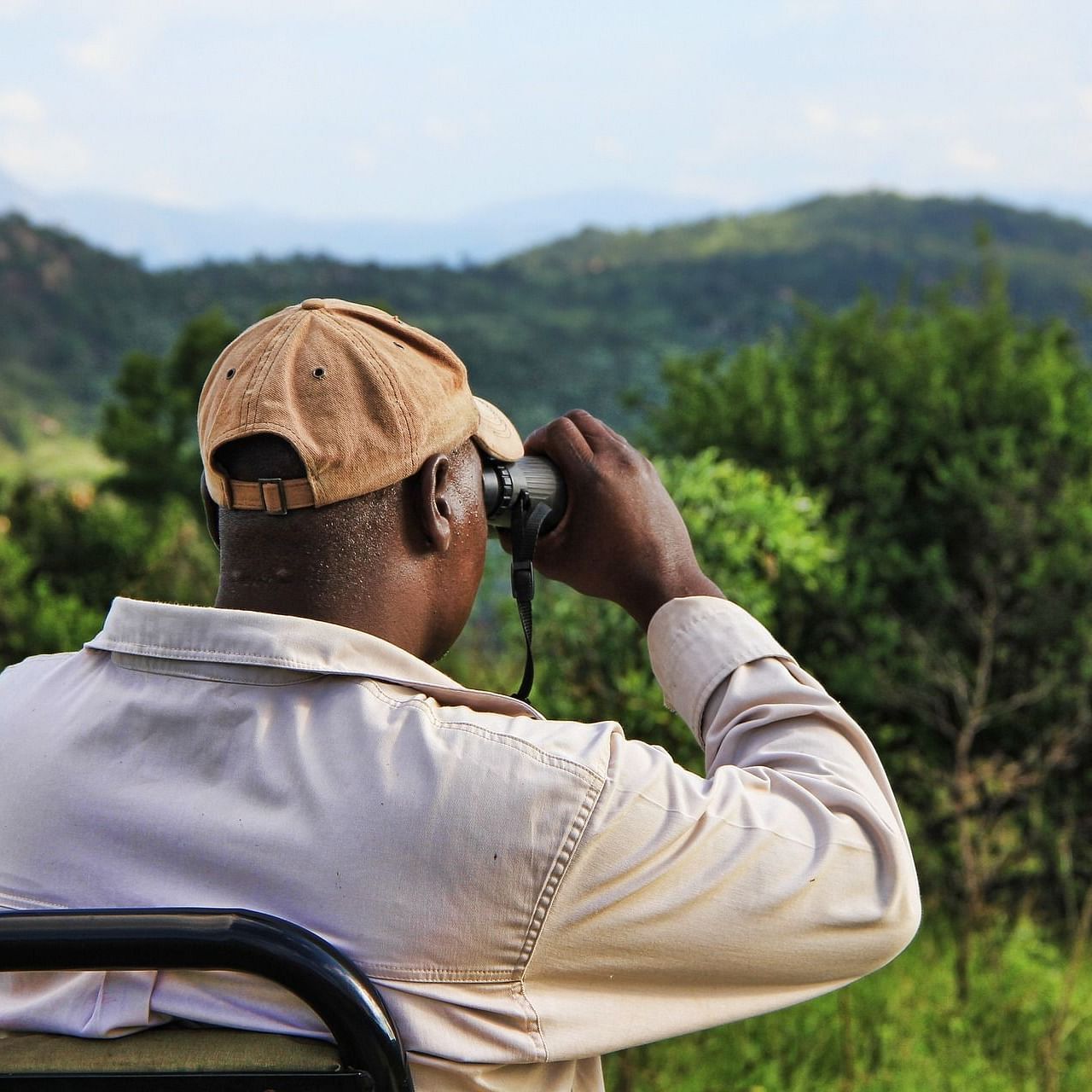 a person looking at the forest scenery with his binoculars