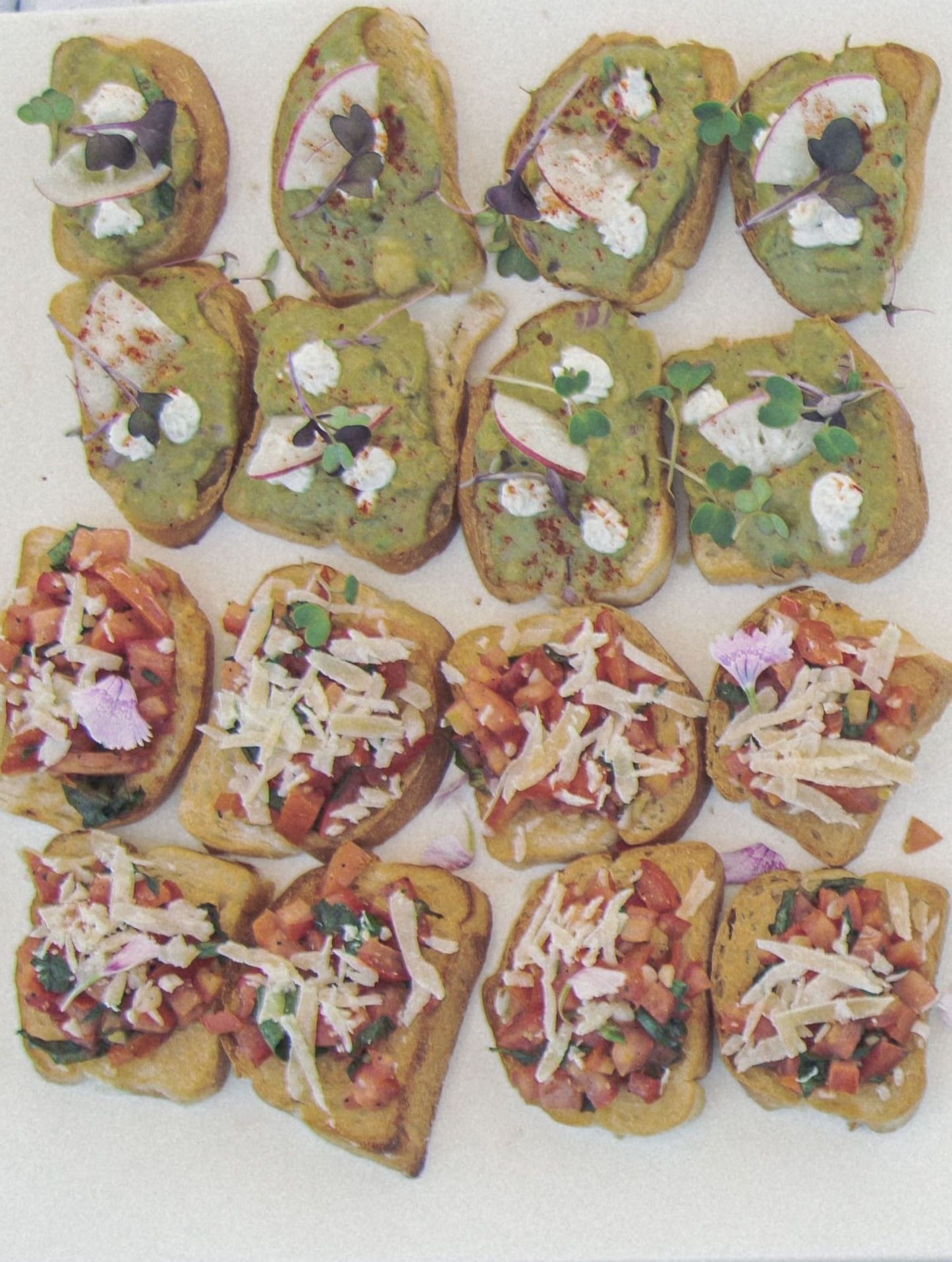 Display of assorted bite-sized snacks or appetisers arranged in rows on a white platter at Fireflies Resorts, Kabini.