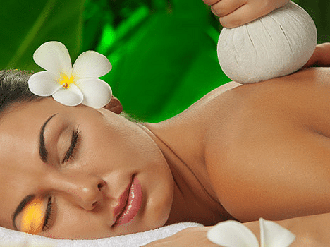 Woman receiving a relaxing massage with flowers and candles around her