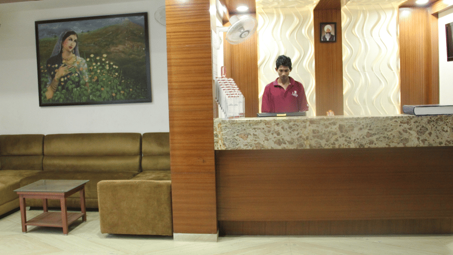 Hotel reception area with staff and wall art in the background