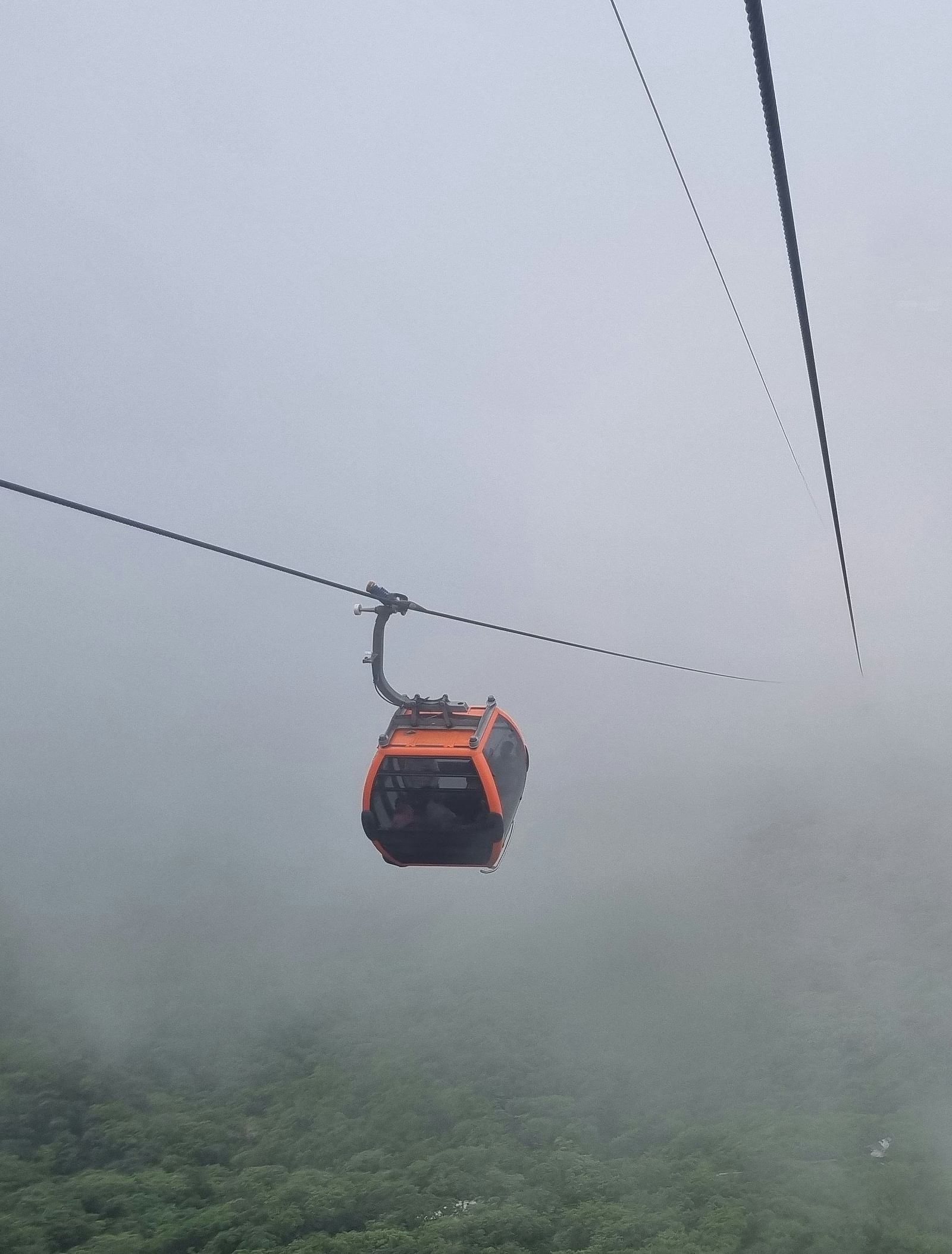 image of a cable car going through the misty mountain valley
