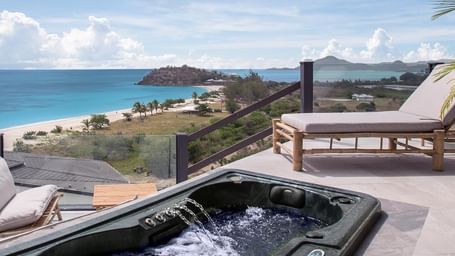 A Jacuzzi on a terrace with outdoor seating and a view of the surrounding landscape at Tamarind Hills Resort and Villas - Antigua.