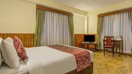 Image of a room with bed and windows on two sides of the room at Summit Tashi Ghang Heritage Resort, Pelling