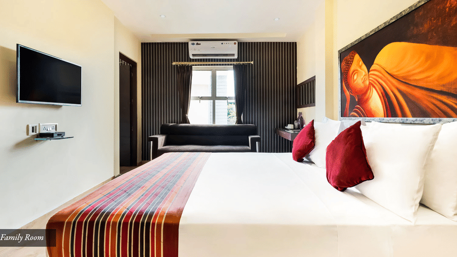 Simple bedroom setup with a bed, wall-mounted TV, and neutral decor.