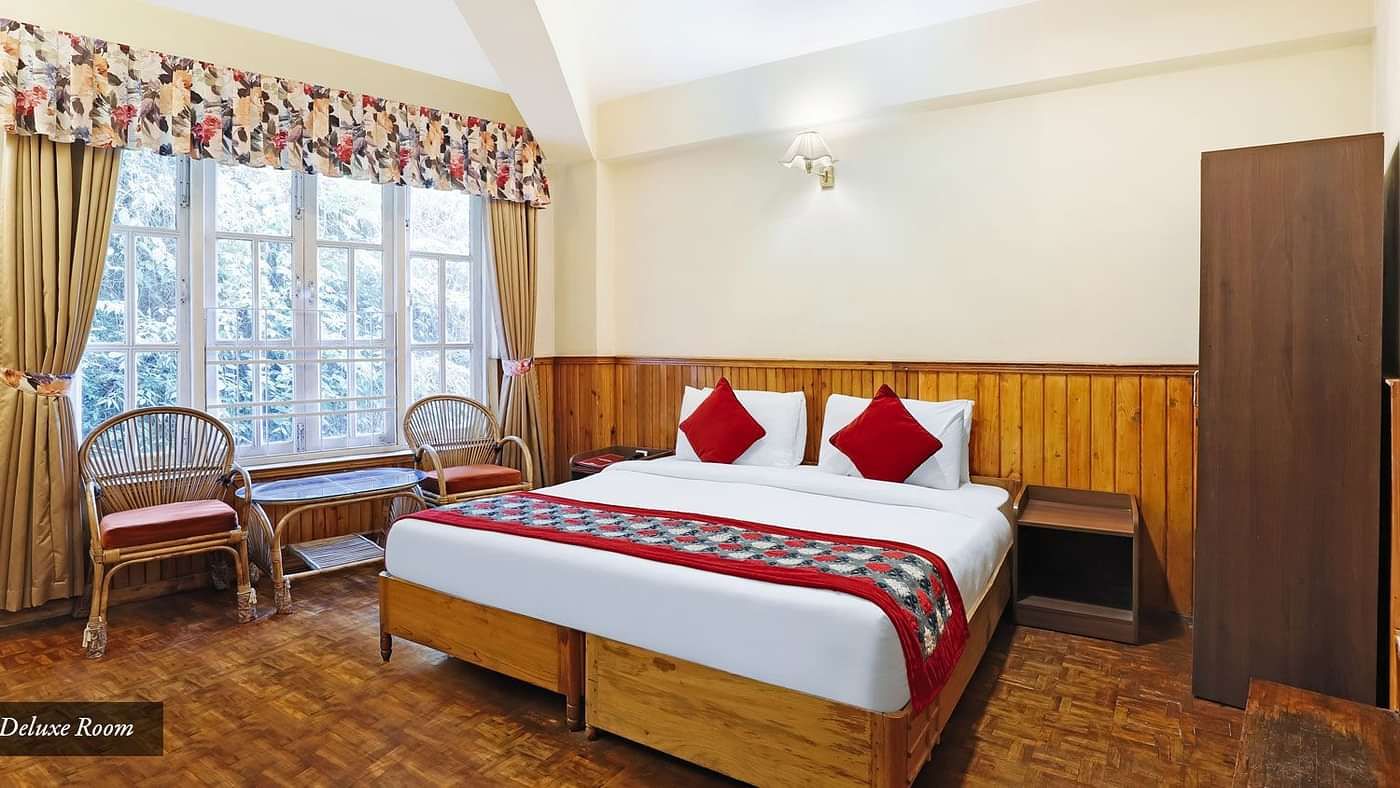A full view of a room that has a bed and a huge glass window | Summit Newa Regency & Spa, Pelling