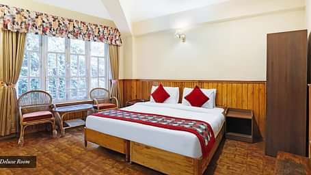 A full view of a room that has a bed and a huge glass window | Summit Newa Regency & Spa, Pelling
