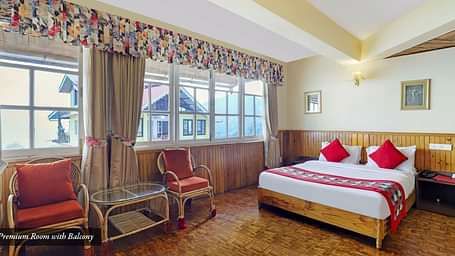 A room with a bed, chairs, and a glass window | Summit Newa Regency & Spa, Pelling