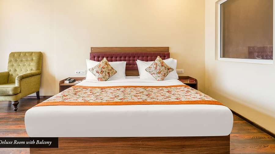 Deluxe room at Summit Barsana Resort & Spa, Kalimpong with a double bed