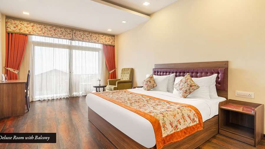 Deluxe room at Summit Barsana Resort & Spa, Kalimpong with a double bed