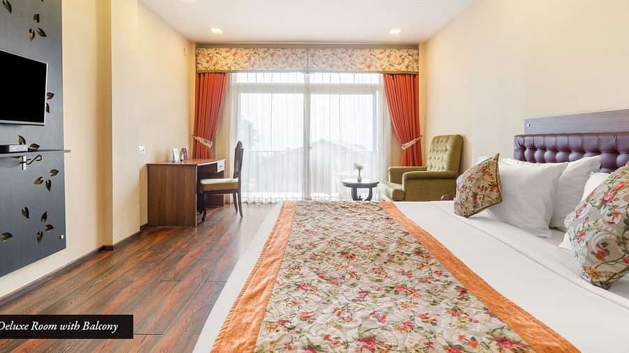 Deluxe room at Summit Barsana Resort & Spa, Kalimpong with a double bed