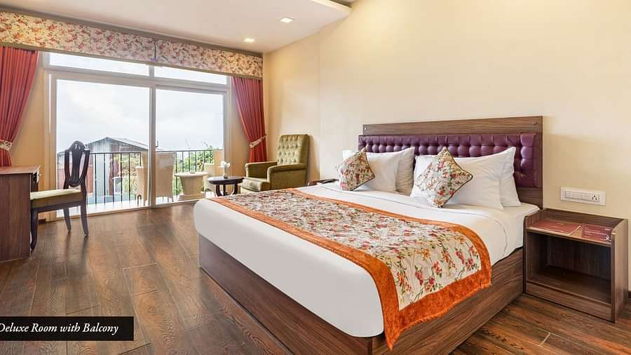 Deluxe room at Summit Barsana Resort & Spa, Kalimpong with a double bed and a balcony