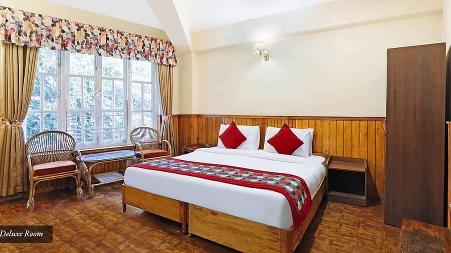 A full view of a room that has a bed and a huge glass window | Summit Newa Regency & Spa, Pelling